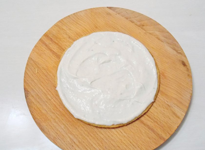 1. Этап. Медово-песочный торт: Возьмите один корж и смажьте его готовым кремом. Сверху положите другой корж, снова смажьте верх кремом.