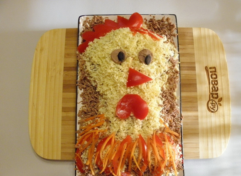 1. Этап. Салат Петушок с корейской морковкой: Силуэт оформите тертой печенью. Из болгарского перца сделайте гребешок, серьги, клювик (я сначала сделала треугольный, но потом сделала разрез посерединке, так более правдоподобно вышло). Сделайте перышки на шее. Салат 