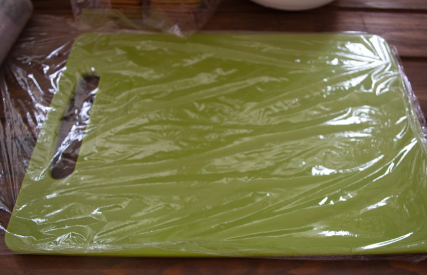 1. Этап. Домик из печенья: Доску застелите пищевой пленкой.