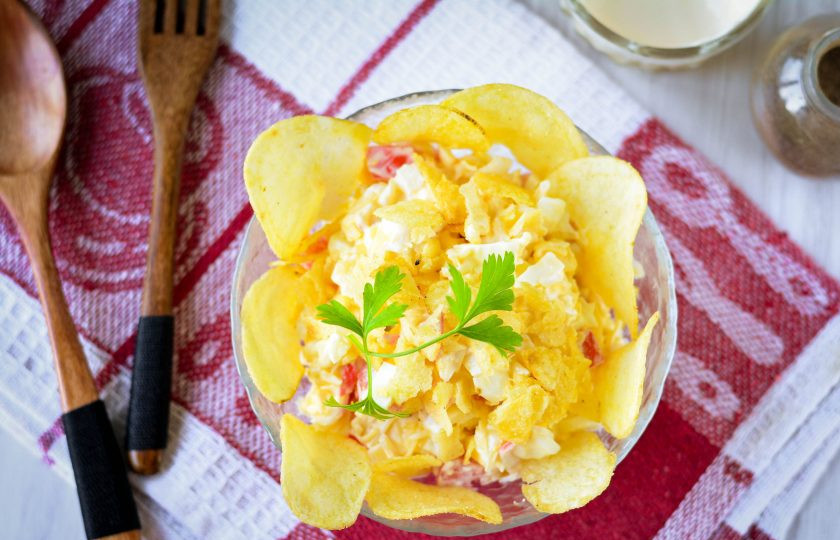 1. Этап. Салат с крабовыми палочками и чипсами: Выложите салат в порционную посуду, присыпьте сверху измельченными чипсами. Также можно дополнительно украсить салат целыми чипсами.