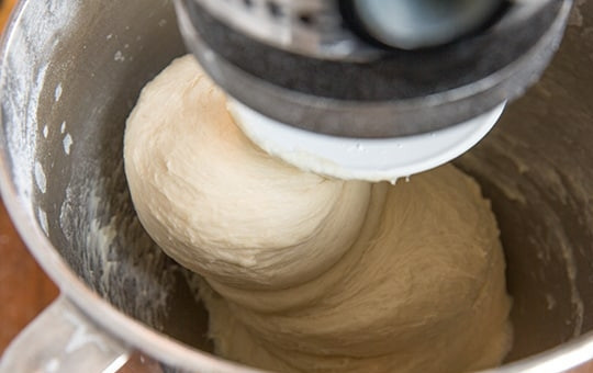 1. Этап. Булочки, как пух: 4. С помощью миксера с крючковым креплением вымешивайте тесто в течение 3-4 минут до получения эластичности. Сначала выставьте низкую скорость, потом увеличьте до средне-низкой. После замешивания плотно накройте миску на 5 минут.