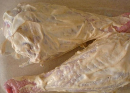 1. Этап. Индейка, запеченная со сметаной: Голени выложите в жаропрочную форму, в которой собираетесь готовить блюдо. Сметану и горчицу равномерно нанесите на мясо. Смешивать их можно как в отдельной посуде, так и непосредственно при нанесении на индюшатину.