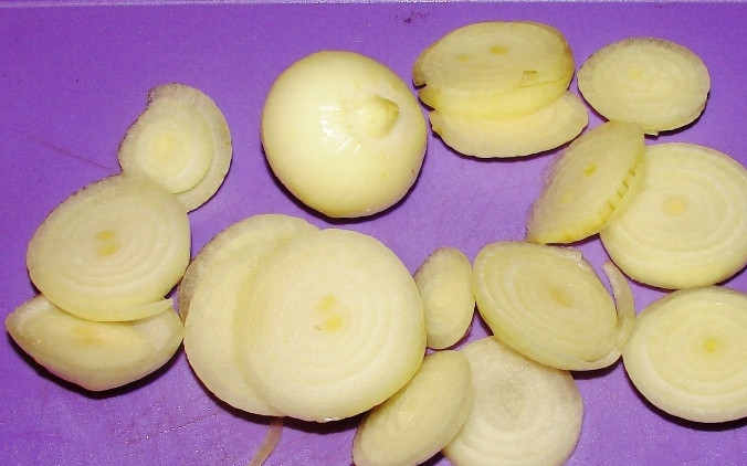 1. Этап. Кролик в фольге: Пока крольчатина маринуется, мы чистим репчатый лук и режем его кольцами.