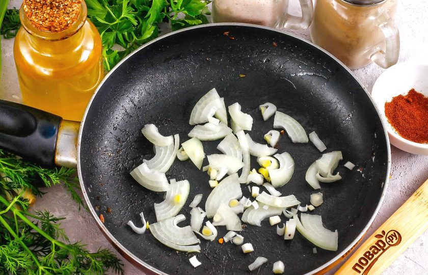 1. Этап. Испанахи: Промойте и очистите репчатый лук, половину овоща нарежьте мелкими кубиками или полукольцами. Обжарьте луковую нарезку в раскаленном растительном масле примерно 2-3 минуты.