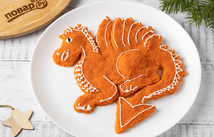 1. Этап. Салат из моркови и тофу на год Дракона: Затем тонкими линиями из майонеза обозначьте контуры дракона, а из кусочка маслины сделайте глаз дракона.