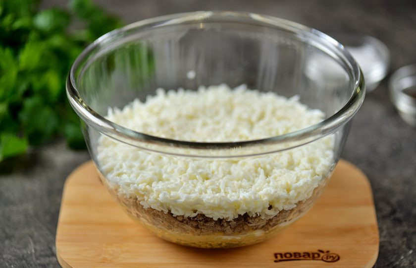 1. Этап. Салат Мимоза классический: На рыбу сверху разложить натёртые белки, смазать майонезом.