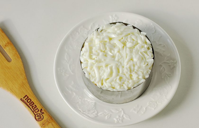 1. Этап. Салат Мимоза с грибами: Смажьте морковь майонезом и выложите тертые белки.