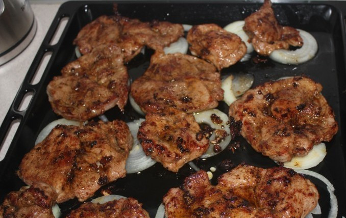 1. Этап. Свинина в соевом соусе: Теперь смазываем противень маслом и выкладываем на него нарезанный кольцами лук, а сверху обжаренное мясо.