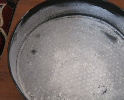 1. Этап. Манник классический на сметане: 4. Смажьте форму маслом, немного присыпьте её мукой. Вылейте тесто в подготовленную форму.