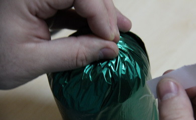 1. Этап. Ананас из конфет: 2. Основу будущего подарка нужно обернуть бумагой или пленкой, плотно заклеив двусторонним скотчем.