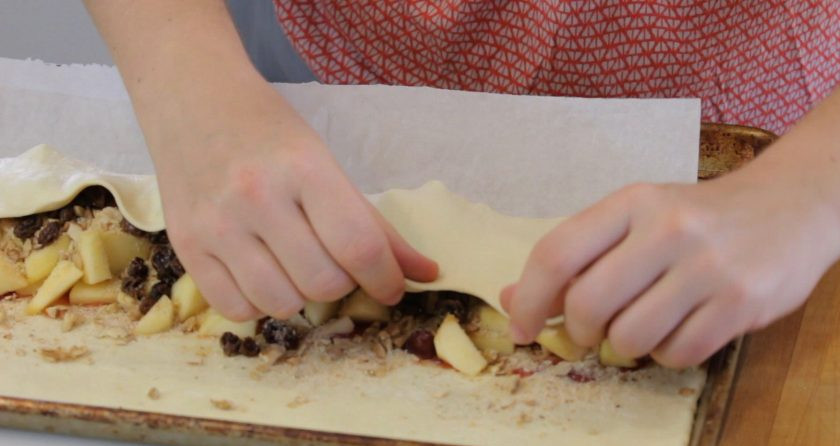 1. Этап. Яблочный штрудель с орехами: 4. Затем посыпьте начинку сухарями, корицей и сахаром. Сверните тесто, закрыв начинку со всех сторон.