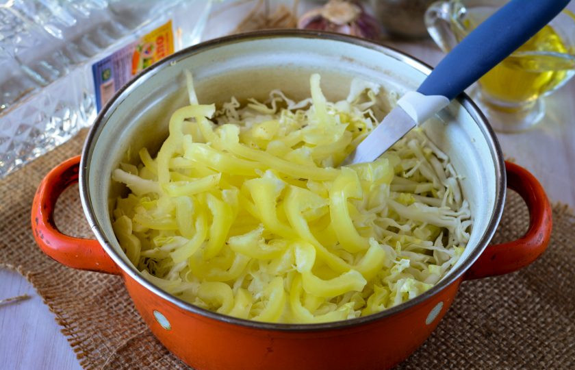 1. Этап. Маринованная капуста с чесноком и перцем: Смешайте капусту с перцем в миске или в кастрюле.