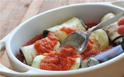 1. Этап. Инвольтини из баклажанов: 4. Сверните пластины рулетами. В форму для запекания на дно вылейте немного томатного соуса. Рулетики положите в соус швом вниз. Вылейте сверху оставшийся соус.