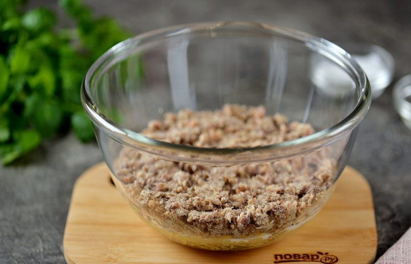 1. Этап. Салат Мимоза классический: Первым делом нужно отварить картофель, морковь и яйца. Отваренные продукты остудить и почистить. На мелкой тёрке натереть картошку, морковку, белки, желтки и сыр (всё в отдельных мисочках или тарелках). В салатницу выложить рыбу с маслом и размять вилкой по всей поверхности дна посуды. Сверху смазать небольшим количеством майонеза.