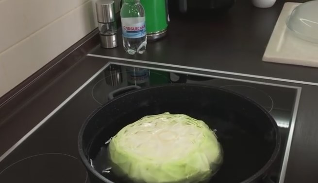 1. Этап. Голубцы с морковкой по-корейски в квашеной капусте: 1. Подготавливаем капусту. Отрезаем кочерыжку, закладываем кочан в крупную кастрюлю с водой. Воду нужно подсолить (чайной ложки достаточно), добавьте чайную ложку масла и 2-3 чайные ложки уксуса. Накройте кастрюлю крышкой, пока вода не вскипит.