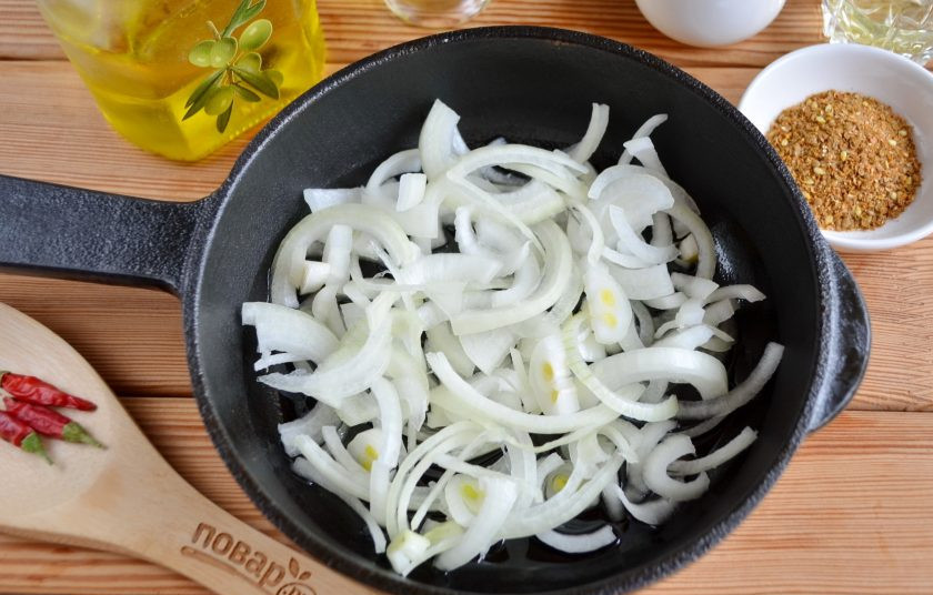 1. Этап. Тыква по-корейски: Луковицу очистите, порежьте тонко полукольцами и обжарьте на растительном масле до мягкости.