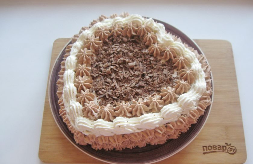 1. Этап. Торт Сердце из медовых коржей: Оставшиеся 200 мл. сливок соедините с какао-порошком и сахарной пудрой. Взбейте коричневый крем. Украсьте этим кремом бока торта и сделайте узор сверху торта. Серединку посыпьте измельченным шоколадом.