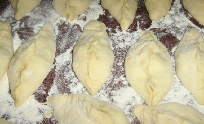 1. Этап. Бабушкины пирожки (самые вкусные): Раскатываем тесто и делим на кусочки, каждый раскатываем в лепешку, а внутрь кладем начинку. Формируем пирожки на присыпанном мукой столе.