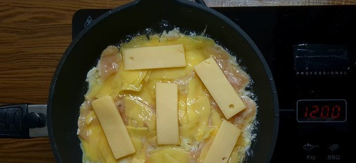 1. Этап. Картофельная запеканка с сыром на сковороде: Разогрейте сковороду с растительным маслом. Выложите половину картофельно-яичной смеси на сковороду, равномерно распределив её. Сверху положите сыр.
