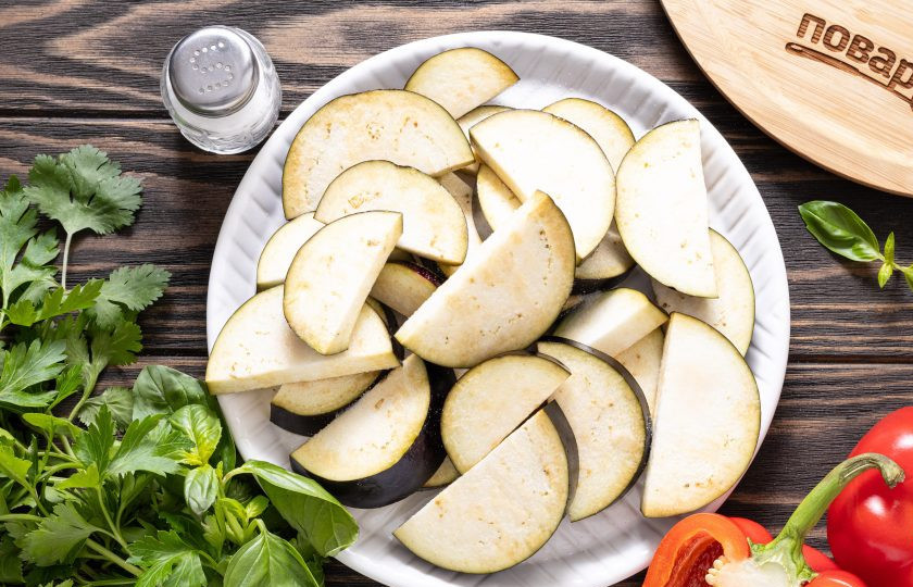 1. Этап. Аджапсандал с баклажаном и чесноком: Баклажаны нарежьте кружочками толщиной примерно 7-8 мм., затем каждый кружочек разрежьте пополам. Подсолите баклажаны и оставьте на полчаса, чтобы они пустили сок, затем промойте в холодной воде и хорошо отожмите.