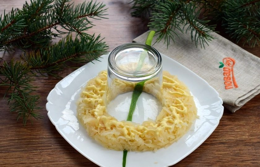 1. Этап. Салат Гранатовый ошейник: На блюдо для подачи положите перо зеленого лука. В центр поставьте стакан дном вверх. Начинайте выкладывать салат слоями вокруг стакана: 1 - картофель, немного майонеза, соль и перец по вкусу.