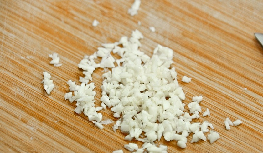 1. Этап. Слоеная картошка со свининой: 2. Очистите и мелко порежьте чеснок.