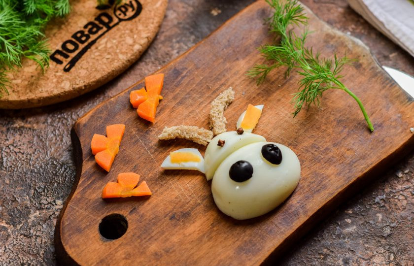 1. Этап. Салат Мимоза на Новый год Быка 2021: Из яйца, маслин и остатков моркови сделайте мордочку быка — как показано на фото.