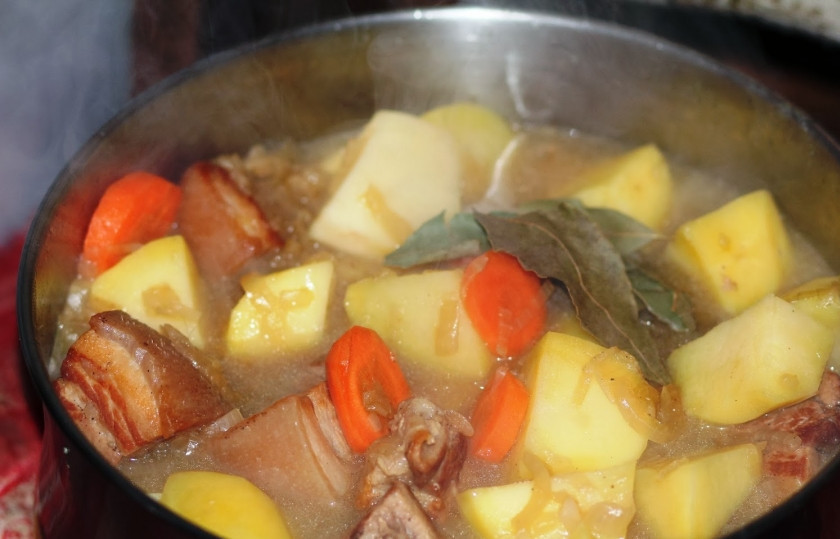 1. Этап. Тушеная свиная корейка: Добавьте овощи в казанок, бросьте лавровый лист. Тушите еще минут 10.