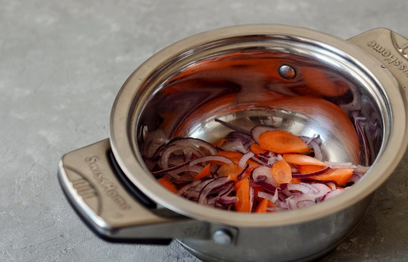 1. Этап. Арахисовый суп: Добавьте лук порезанный полукольцами и морковь кружочками. Обжарьте овощи до мягкости.