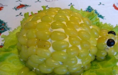 1. Этап. Салат Черепаха с виноградом: Достанем салат из холодильника и украсим блюдо листьями салата. Выкладываем ягоды винограда и формируем мордочку черепашки.