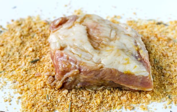 1. Этап. Свиные ребрышки в кукурузных хлопьях: Обваляйте каждый кусок мяса с ребрышком в кукурузных хлопьях.