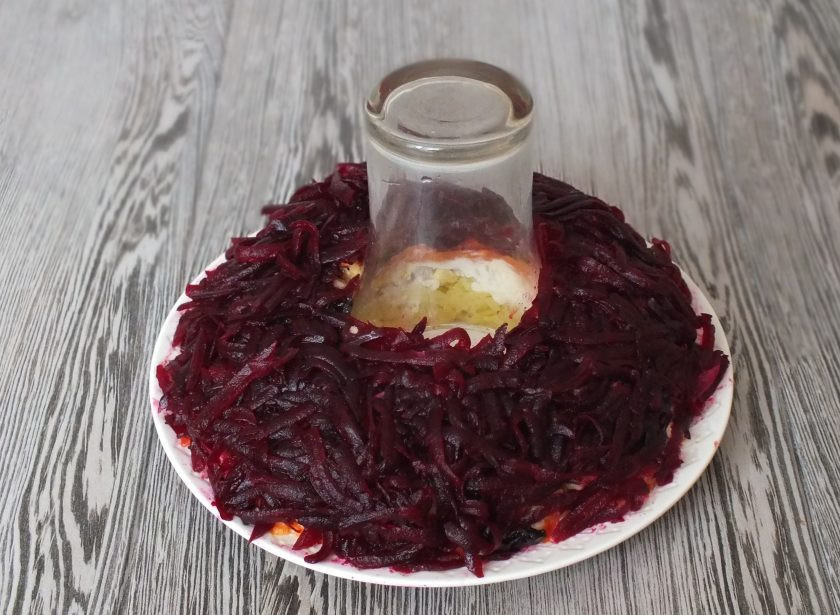 1. Этап. Салат Гранатовый браслет с черносливом и грецким орехом: Натрите свеклу на крупной терке, разложите на предыдущий слой.