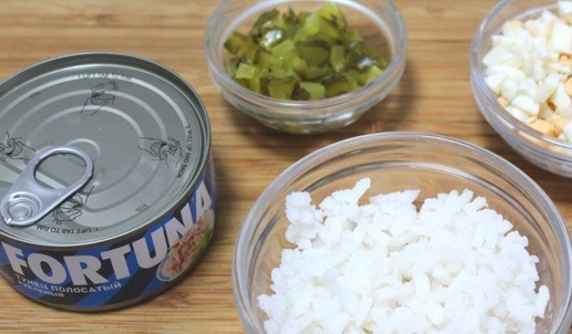 1. Этап. Салат с тунцом и маринованными огурцами: Отварить рис, остудить. Яйцо порезать средним кубиком. Огурцы порезать мелким кубиком. Тунец отцедить