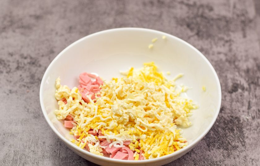 1. Этап. Закуска «Ракушки» из слоеного теста с начинкой: Сюда же натрите на мелкой терке плавленый сыр и зубчик чеснока.