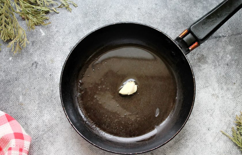 1. Этап. Паста с креветками и соусом Песто: Чеснок очистите и немного раздавите широкой стороной лезвия ножа. В сковороду налейте растительное масло и разогрейте на среднем огне. Добавьте в масло чеснок и обжаривайте в течение 30 секунд, чтобы масло стало ароматным.