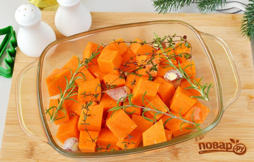 1. Этап. Брускетты Елочки на Новый год Тигра: Разогрейте духовку до 200 градусов. Тыкву очистите от кожуры и внутреннего волокнистого края. Плотную часть тыквы порежьте кубиками. Выложите на противень или в удобную форму для запекания. Добавьте соль, перец, розмарин тимьян, чеснок (срежьте край, где были корешки, а чистить не нужно, чтобы чеснок не сгорел). Полейте растительным маслом и запеките до мягкости, примерно 35-40 минут.