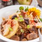 Тушеная капуста с яблоками Капусту тонко нашинковать, сложить в глубокую миску, полить сладким соевым соусом Киккоман и перетереть руками до мягкости. Такая капуста имеет жизнерадостный цвет, приобретает приятный вкус и аромат. Свинину нарезать небольшими кусочками, посолить, поперчить и обжарить на растительном масле вместе с полукольцами репчатого лука. Жарить до побеления мяса, внутри оно остается сырым. Переложить мясо с луком в чугунный казанок, соки и жир оставить на сковороде. В мясных соках кратко обжарить дольки яблок. Переложить их сверху на мясо, немного поперчить. Сверху положить чернослив без косточек. Я его нарезала на небольшие кусочки. В остатках жира на сковороде, помешивая, обжарить капусту. Жарить недолго, минут 5-7. Переложить капусту в чугунок, сбрызнуть уксусом для суши, посолить, поперчить. Накрыть крышкой и тушить на среднем огне 30-40 минут. Перед подачей перемешать.