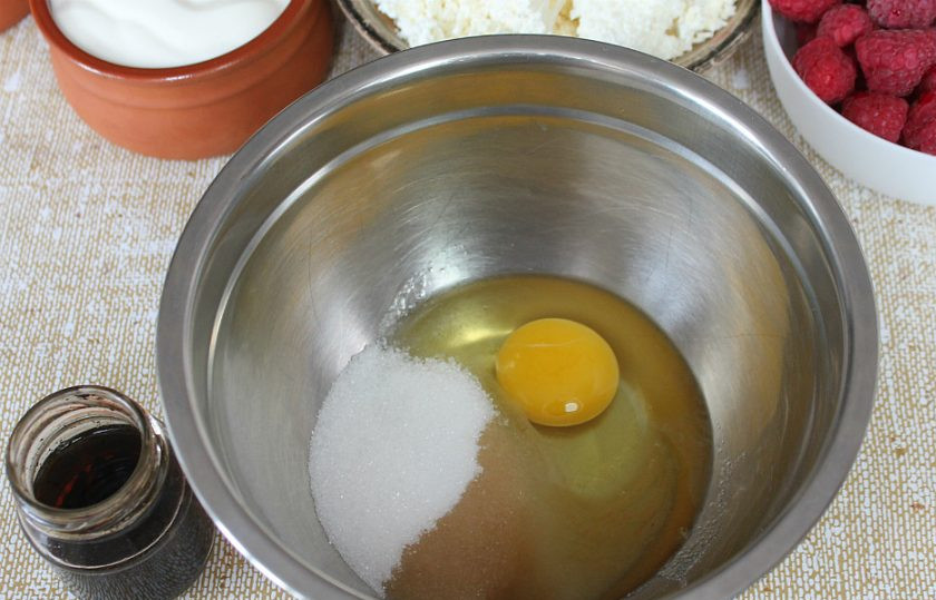 1. Этап. Малиновый торт Летний: В миску насыпаем треть стакана сахара, добавляем яйцо и настойку.
