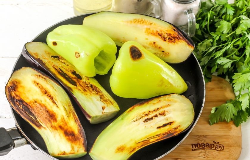 1. Этап. Бадымджан: Влейте немного растительного масла в сковороду и выложите половинки баклажанов срезом вниз и болгарские перцы. Обжарьте примерно 10 минут.