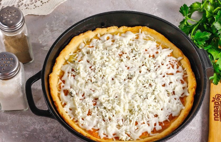 1. Этап. Сырный пирог: В глубокую форму с бортиками выложите тесто, слегка заходя на бортики. Нарежьте бекон мелкими кубиками и выложите в середину. Влейте приготовленную начинку и поместите пирог в разогретую до 180 градусов духовку на 25 минут. Спустя указанное время извлеките пирог и присыпьте оставшимся натертым сыром. Поместите в духовку еще на 5-8 минут.