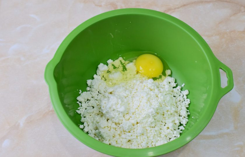 1. Этап. Сырники в вафельнице: В чашу выложите творог и добавьте к нему яйцо. Смешайте.