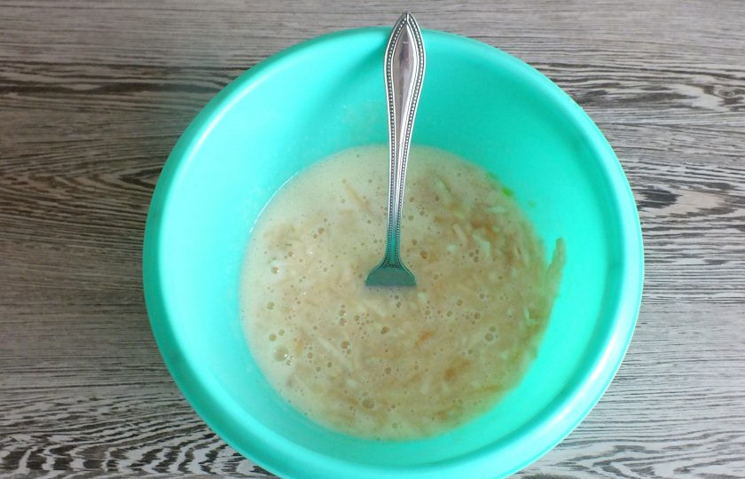 1. Этап. Овсяное печенье с яблоком на кефире: Добавьте натертые яблоки в яично-кефирную смесь. Перемешайте.