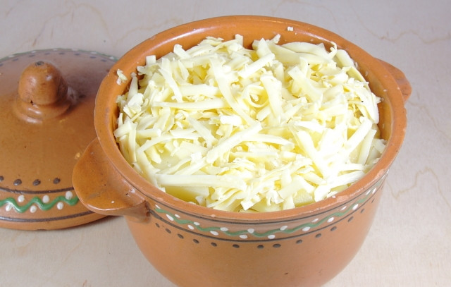 1. Этап. Картофель тушеный в горшочке: В горшочек сложить картофель, чеснок, посолить. Влить молоко и сверху засыпать тертый сыр.