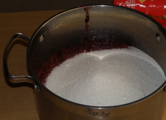 1. Этап. Варенье из смородины без воды: Перекладываем ягодную массу в кастрюлю и добавляем сахар.