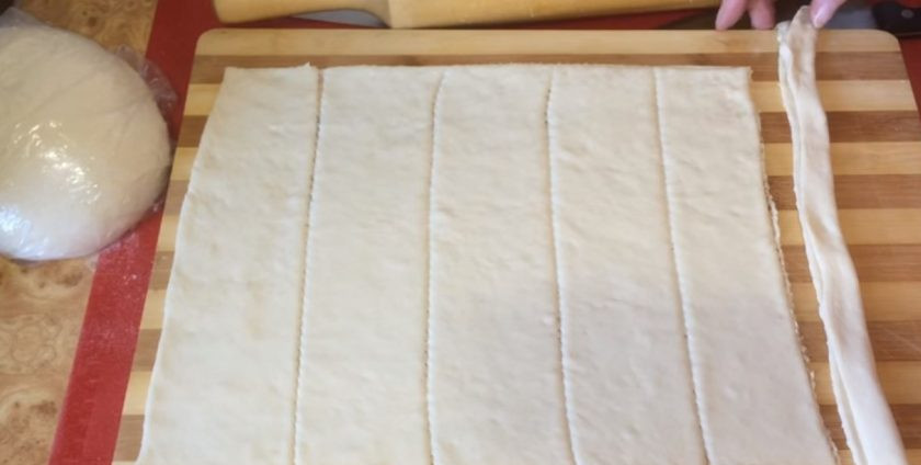 1. Этап. Паровые булочки (штрули): 6. Отрежьте от прямоугольника 1 полоску, сложите пополам вдоль длинны, после чего скатайте в рулетик. Подкрутите основание рулета, придав ему форму розочки.