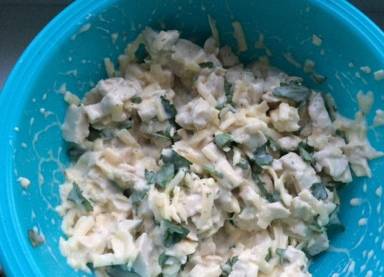 1. Этап. Куриные маффины с сыром: Добавьте в смесь из первого шага курицу, измельченную зелень и муку. Перемешайте.