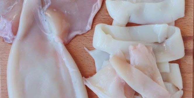 1. Этап. Салат из кальмара с огурцом: Кальмары, если они были замороженными, достаньте из морозилки, дайте им постоять в тепле, чтобы они оттаяли. Затем вымойте их, почистите и нарежьте крупными кусками.