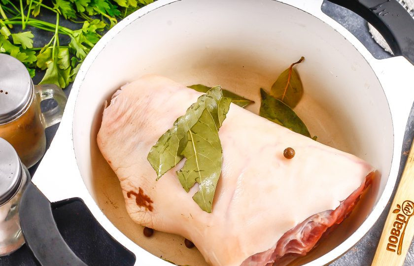 1. Этап. Свиная рулька в вине: Выложите ее в казан или кастрюлю с антипригарным дном. Добавьте лавровые листья, горошины черного перца и другие пряности по своему вкусу.