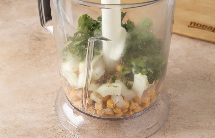 1. Этап. Фалафель в пите с салатом и помидором: Измельчите нут с луком, чесноком и кинзой в блендере или через мясорубку. Добавьте соль, чёрный молотый перец и кориандр, ещё раз все измельчите до однородности.