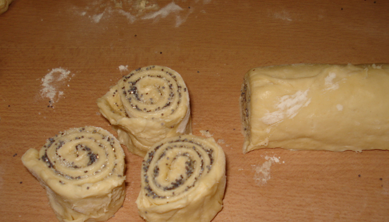 1. Этап. Булочки из слоеного дрожжевого теста: Сверните тесто в плотный рулет и разрежьте на порционные части. Переложите будущие булочки ан противень, застеленный бумагой для выпечки. Оставьте в теплом месте на 2 часа.